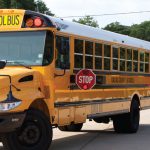 When the stop sign on a school bus is extended, drivers must come to a complete stop behind the bus or face significant fines.