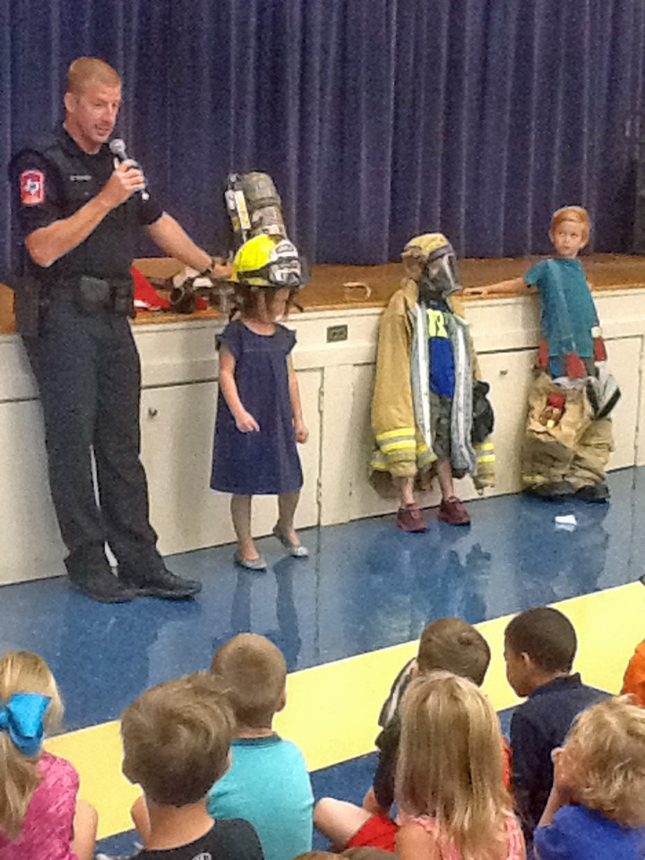 Kindergarten students try on firefighters' gear.
