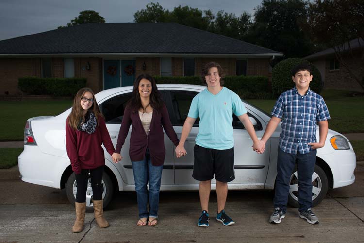 From left: Sara, Teresa, Samuel and Matthew Hendricks pose for a photo outside their Plano home November 1, 2015. The family lost their father who had a car repair accident in the garage. The Hendricks were gifted a brand new Chevy Aveo for Samuel by former Dallas Cowboys’ Bradie James and Terence Newman. (Photo by Rasy Ran)