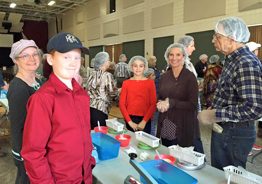 Volunteers prepare meal packets
