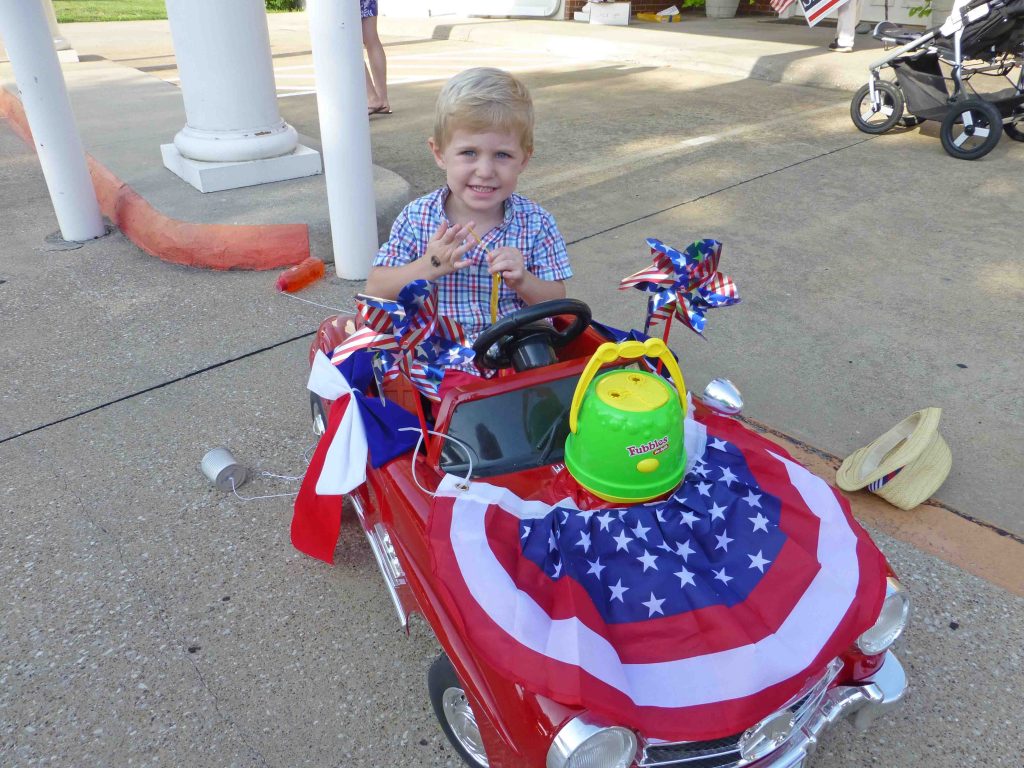 Boy wins a ribbon for his decorated car at the parade