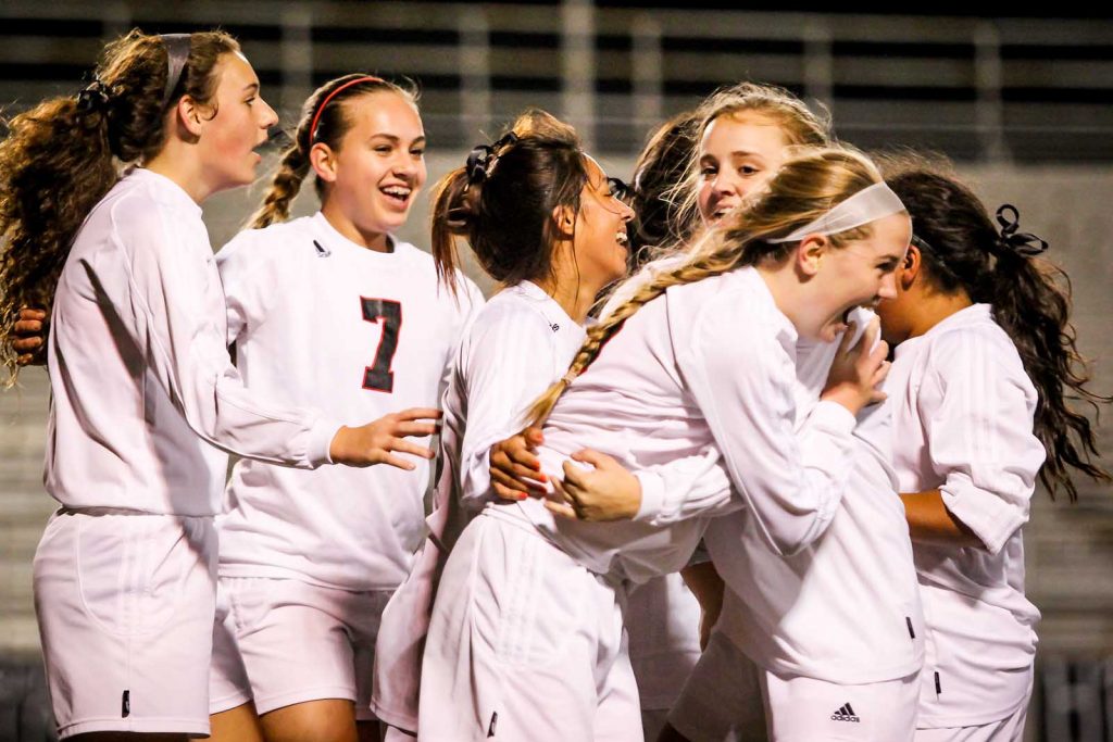 Lady Cats congratulate Flinn on her game-tying goal. Photo by Jeff Bargas.