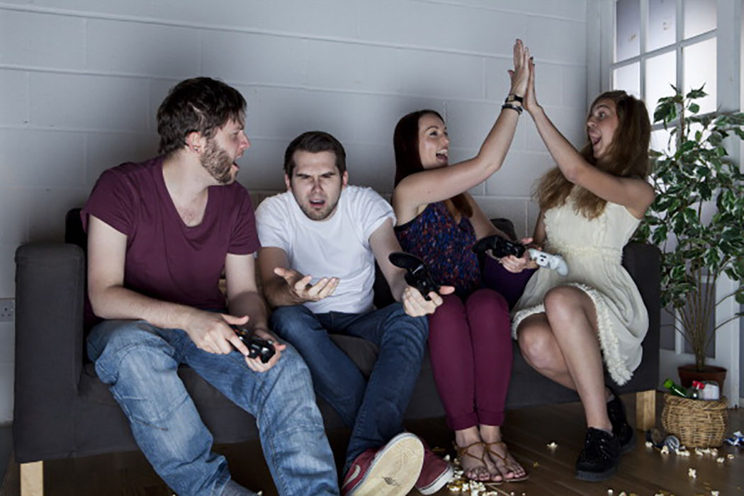 A group of young men and women with various expressions of happiness, anger and confusion playing Sony PlayStation 3 video games on a sofa, taken on July 9, 2013. (Photo by Philip Sowels/Future Publishing via Getty Images)