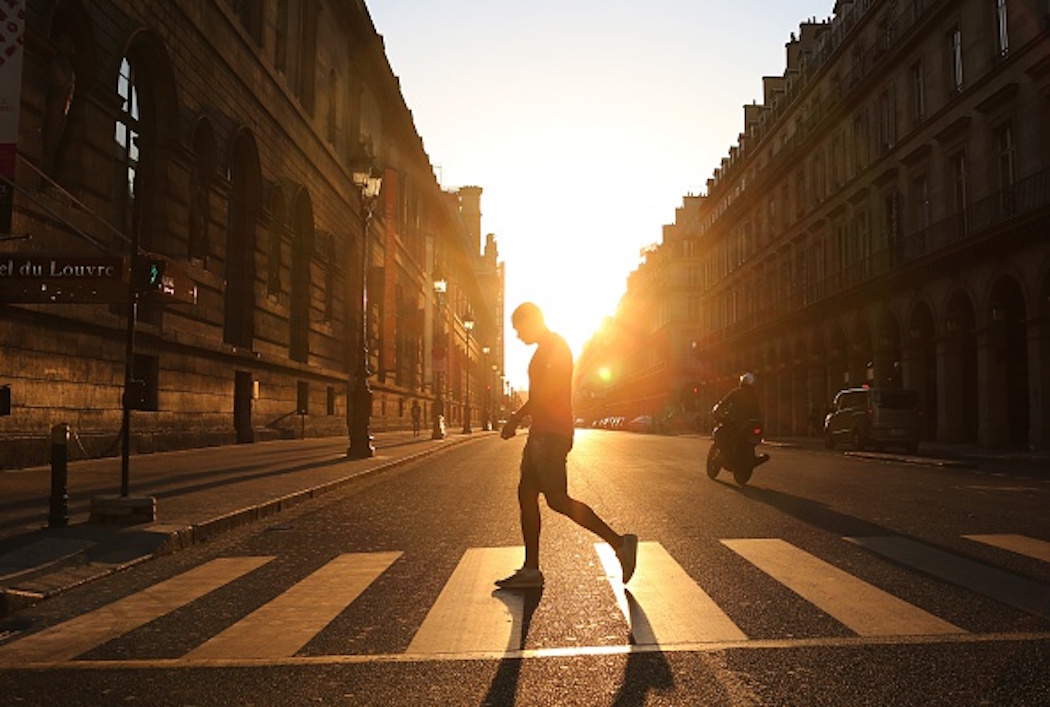 A man walks across the Rivoli street along the Louvre museum at sunset in Paris on June 8, 2015. (Photo by LUDOVIC MARIN/AFP/Getty Images)