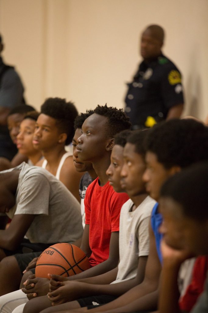A youth member listens to adult volunteers during the final of eight midnight basketball sessions. (Photo by Rasy Ran)