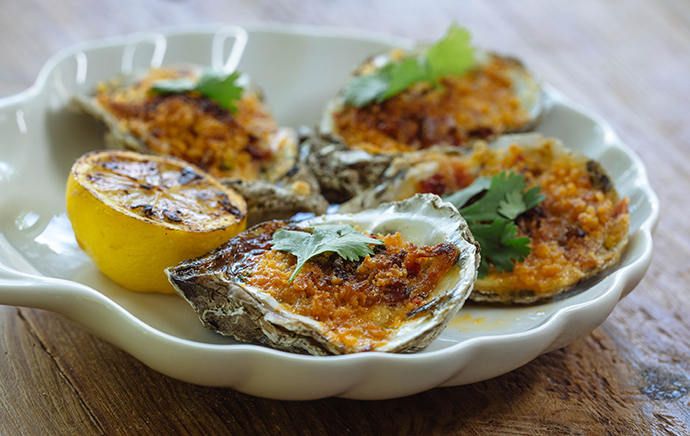 Roasted oysters with bacon, breadcrumbs and red pepper butter. (Photo by Kathy Tran)