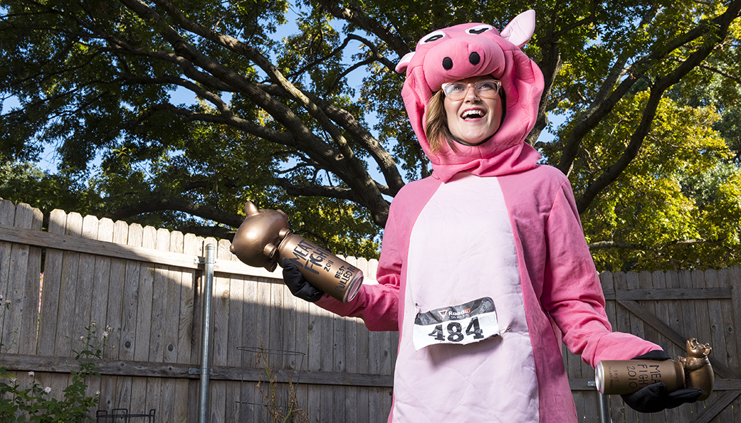 Alice Laussade in a pig costume holding Meat Fight trophies (Portrait by Danny Fulgencio)