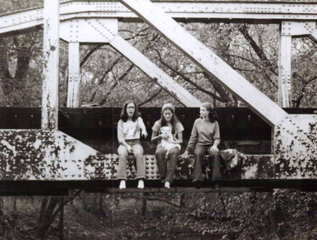 Below, Rhonda Tucker Seaton-McNeill, Debbie Goodwin Lloyd and Micha Aldon perch on the bridge over White Rock Creek in 1977 or ‘78. (Photo courtesy of Rhonda Tucker Seaton-McNeill).