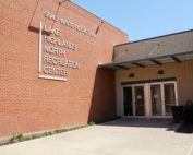 A set of doors leading into a brick building. The sign next to the doors says "Lake Highlands North Recreation Center."