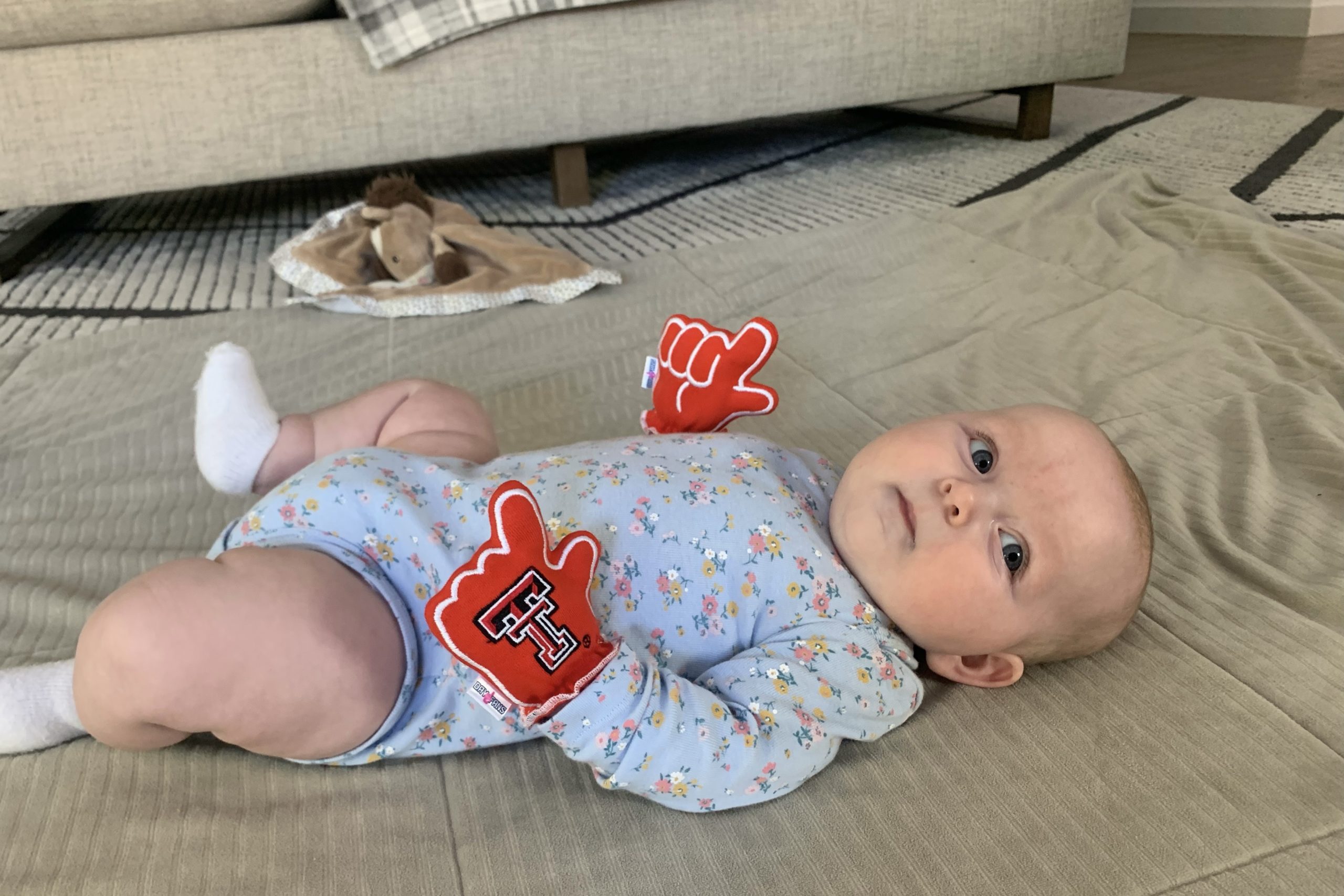 Baby wears Texas Tech mittens